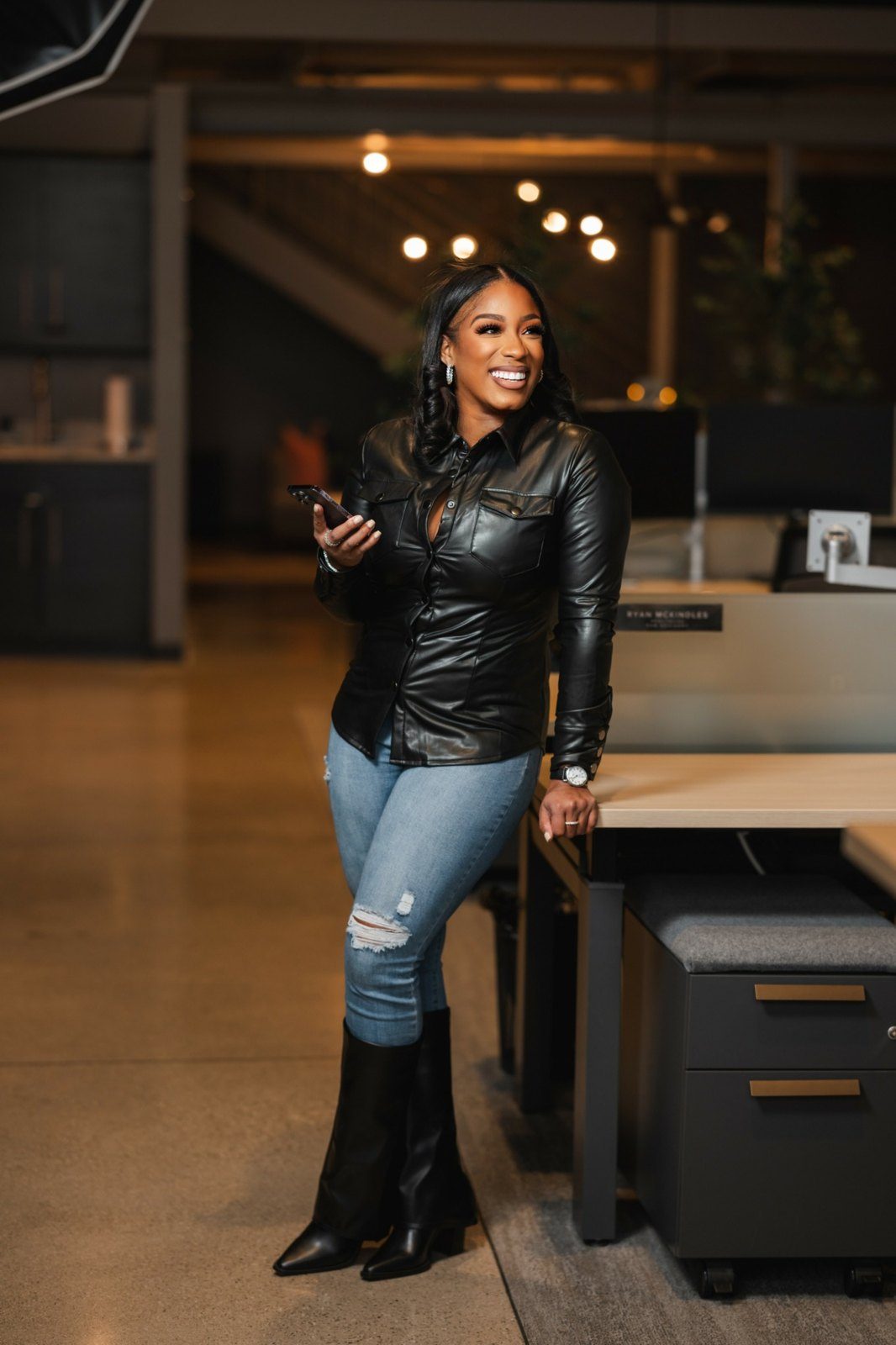 Brittany Mobley smiling with her phone in an office
