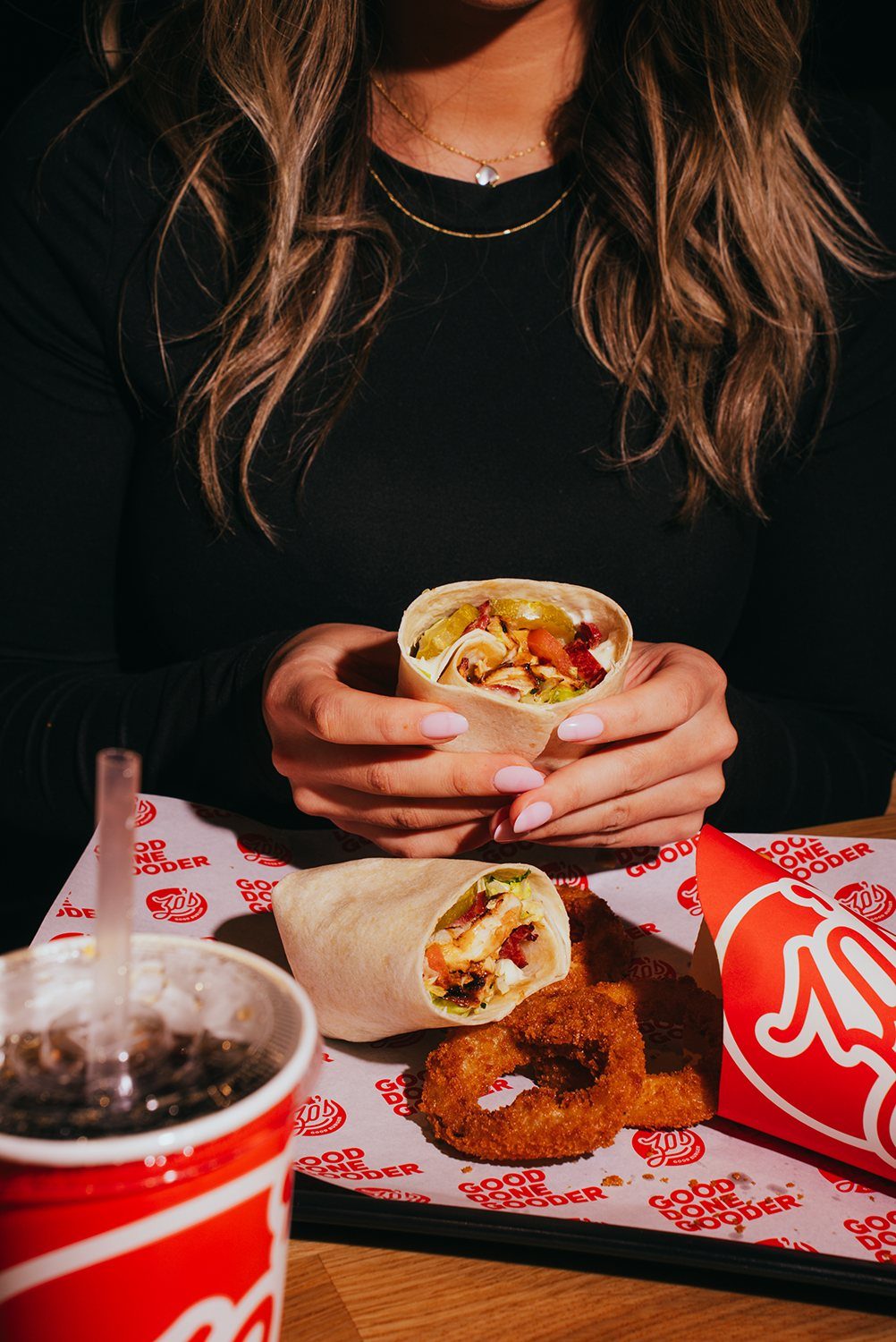 A Zo's wrap with onion rings and a drink